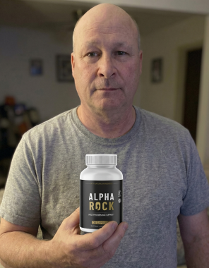 An adult man at home holding a bottle of AlphaRock capsules, shown as an illustrative editorial visual